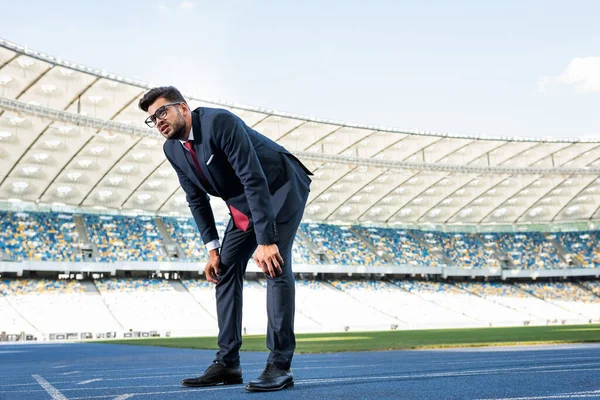 Jeune homme d'affaires en costume sur piste de course au stade — Photo de stock