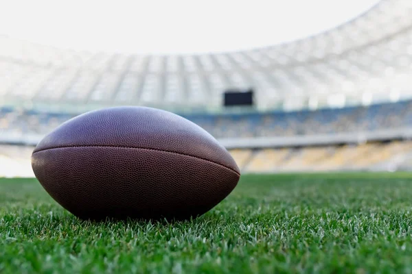 Rugby ball on green grass at stadium — Stock Photo