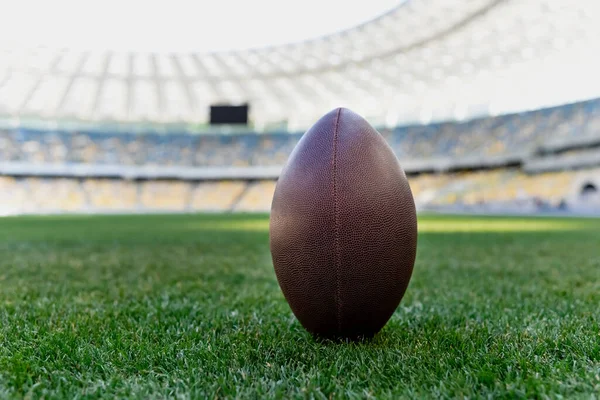 Rugby ball on green grass at stadium with copy space — Stock Photo