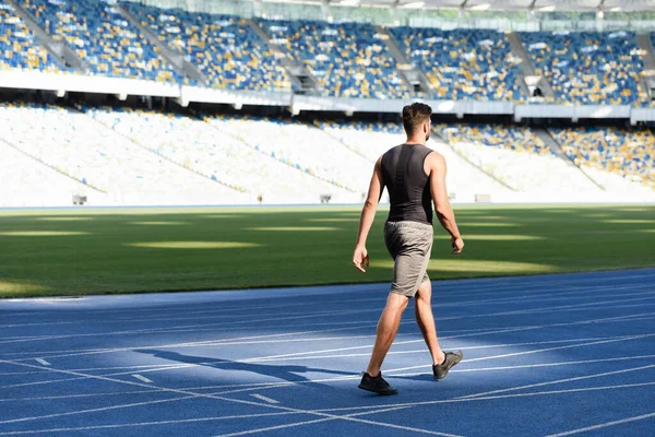 Corredor bonito na posição inicial na pista de corrida no estádio — Fotografia de Stock