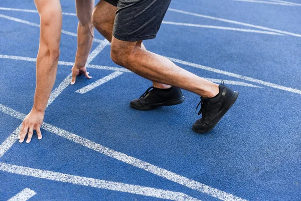 Обрізаний вид бігуна на стартовій позиції на біговій доріжці на стадіоні — стокове фото