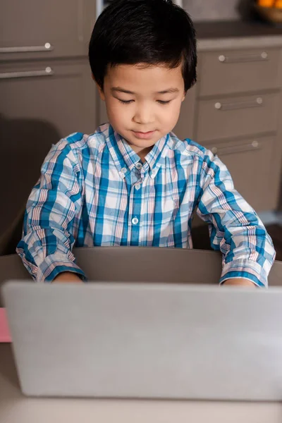 Asian boy studying online with laptop at home during quarantine — Stock Photo