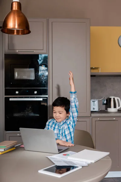 Carino asiatico ragazzo con mano fino studiare online con laptop a casa durante auto isolamento — Foto stock