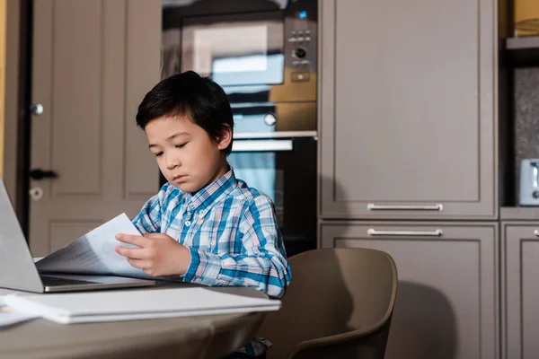 Bonito ásia menino estudar online com laptop no casa durante auto isolamento — Fotografia de Stock