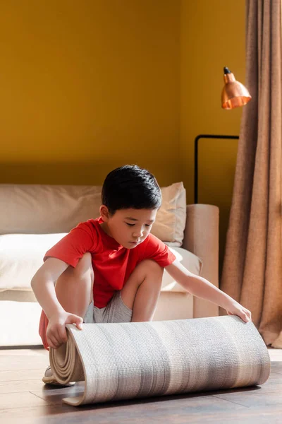 Мальчик с фитнес-ковриком дома во время самоизоляции — стоковое фото