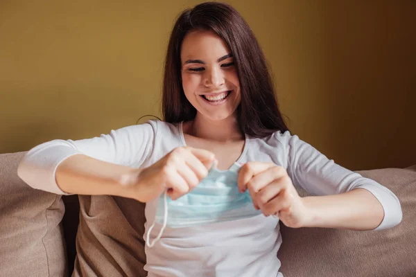 Selective focus of smiling woman tearing medical mask, end of quarantine concept — Stock Photo