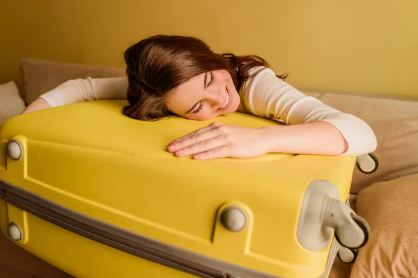Happy young woman lying on luggage, end of quarantine concept — Stock Photo