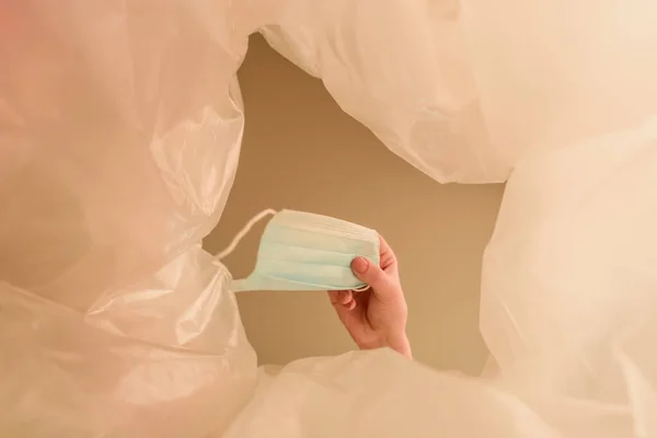 Vue du bas de la femme jetant un masque médical dans une poubelle, concept de fin de quarantaine — Photo de stock