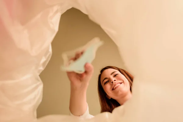 Vue du bas de la femme heureuse jetant un masque médical dans une poubelle, concept de fin de quarantaine — Photo de stock