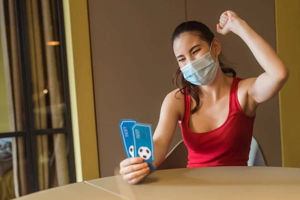 Cheerful woman in medical mask holding sport match tickets — Stock Photo