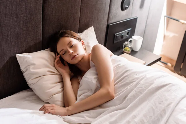 Attraktive und schwangere Frau schläft unter Decke im Bett — Stockfoto