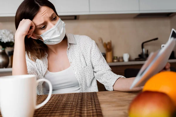 Enfoque selectivo de la mujer embarazada en máscara médica mirando ultrasonido cerca de frutas - foto de stock