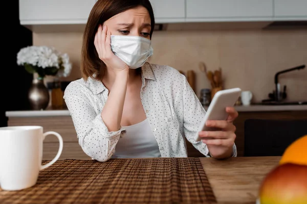 Selective focus of pregnant woman in medical mask using smartphone — Stock Photo