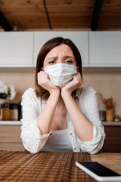 Selective focus of pregnant woman in medical mask near smartphone with blank screen — Stock Photo