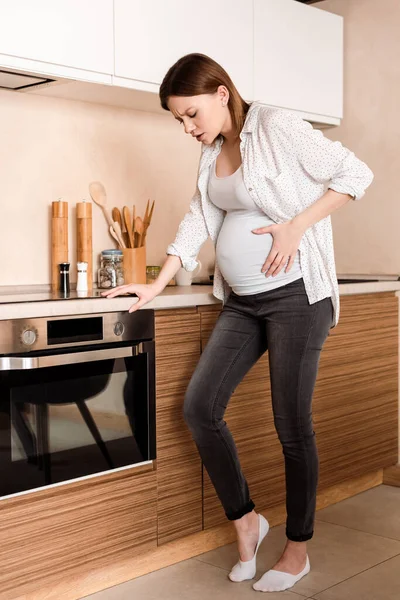 Femme enceinte ayant des crampes et souffrant de douleur — Photo de stock