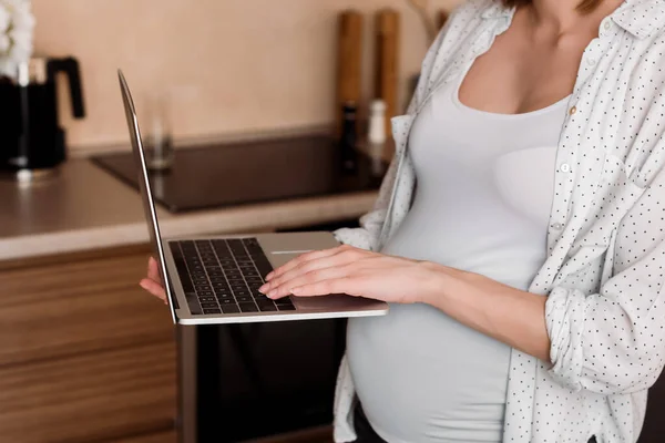 Visão cortada de freelancer grávida usando laptop — Fotografia de Stock