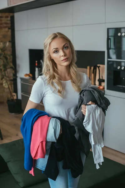 Müde Hausfrau blickt beim Wäschewaschen in die Kamera — Stockfoto