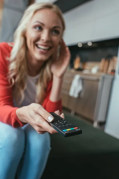 Foyer sélectif de femme excitée riant tout en regardant la télévision à la maison — Photo de stock