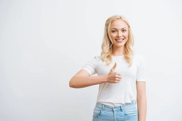 Glückliches attraktives Mädchen zeigt den Daumen nach oben, während es isoliert auf Weiß in die Kamera lächelt — Stockfoto