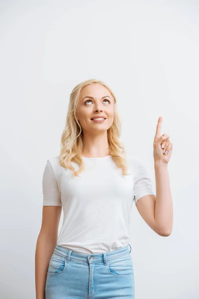 Sorridente ragazza guardando in alto e puntando con il dito isolato su bianco — Foto stock