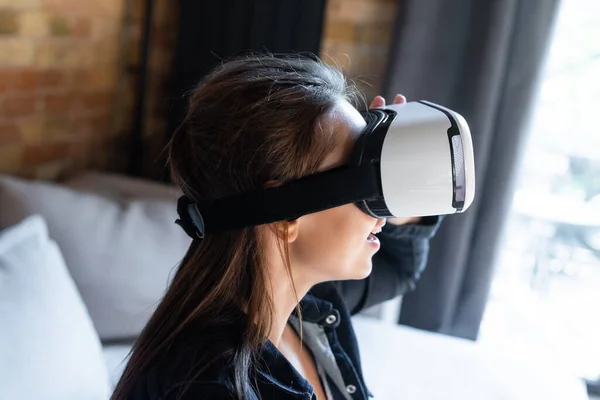 Aufgeregte Frau im Virtual-Reality-Headset zu Hause — Stockfoto