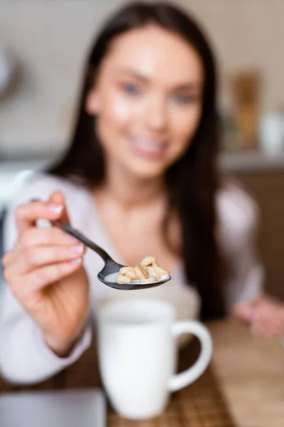 Foyer sélectif de fille gaie tenant cuillère avec des flocons de maïs savoureux avec du lait — Photo de stock