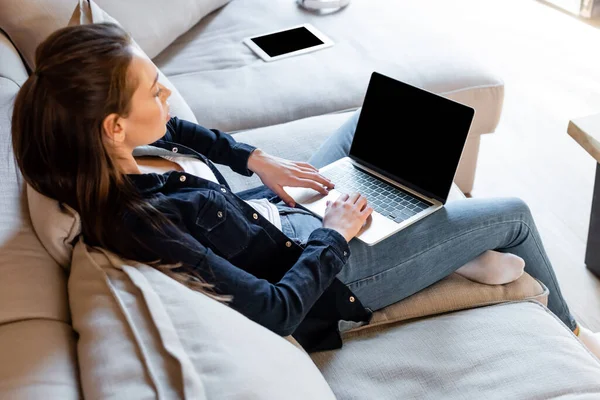 Selective focus of freelancer using laptop with blank screen near digital tablet — Stock Photo