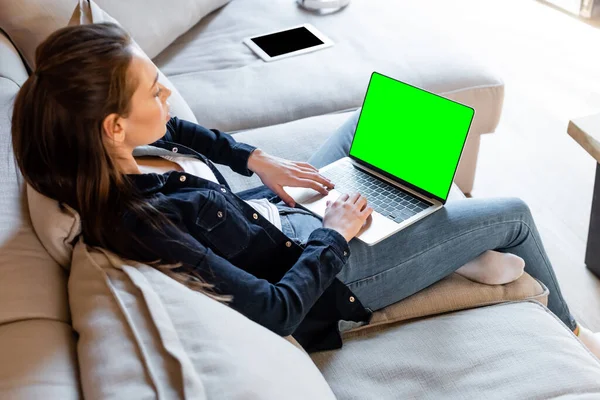 Selective focus of freelancer using laptop with green screen near digital tablet with blank screen — Stock Photo