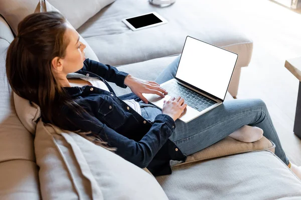 Selective focus of freelancer using laptop with white screen near digital tablet with blank screen — Stock Photo