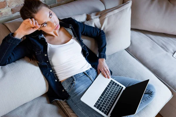 Visão aérea de freelancer cansado usando laptop com tela em branco — Fotografia de Stock