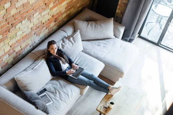 KYIV, UKRAINE - APRIL 29, 2020: overhead view of attractive freelancer using laptop near digital tablet with tumblr app — Stock Photo