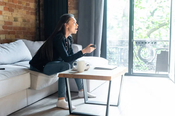 KYIV, UKRAINE - APRIL 29, 2020: emotional woman holding joystick while playing video game in living room — Stock Photo