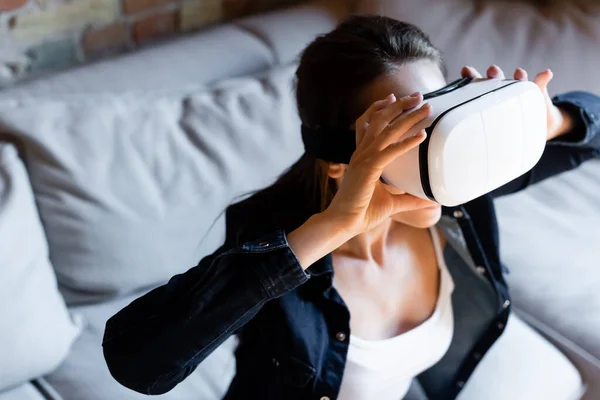 Selective focus of young woman touching virtual reality headset — Stock Photo