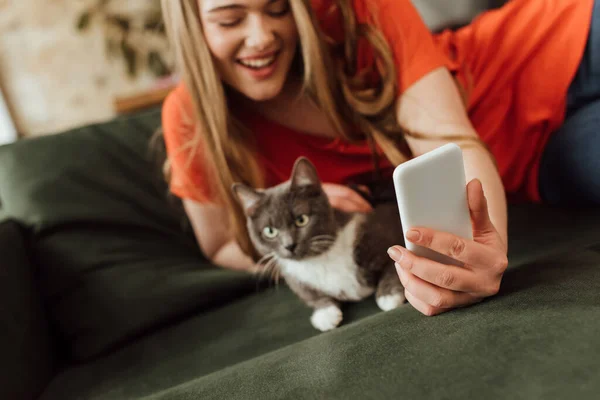 Selective focus of smiling woman taking selfie with cat — Stock Photo