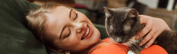 Panoramic concept of cheerful woman looking at cute cat — Stock Photo