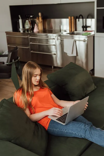 Beautiful and young freelancer using laptop in living room — Stock Photo