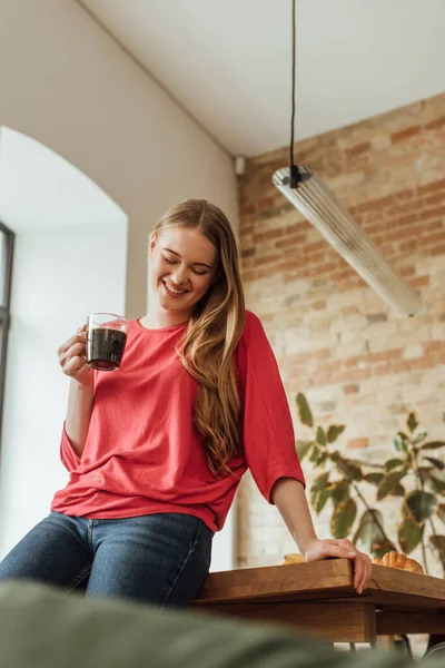 Selektiver Fokus einer fröhlichen Frau mit einer Tasse Kaffee — Stockfoto