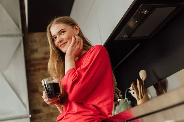 Selektiver Fokus einer fröhlichen Frau mit einer Tasse Kaffee und einem anrührenden Gesicht — Stockfoto
