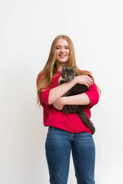 Heureuse jeune femme tenant dans les bras moelleux chat isolé sur blanc — Photo de stock