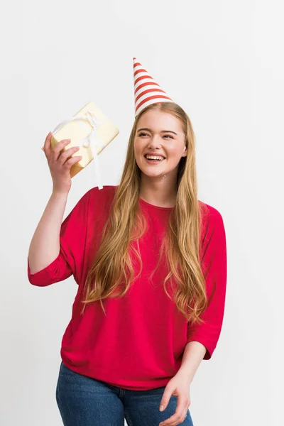 Щаслива дівчина у вечірній кепці тримає подарунок ізольовано на білому — стокове фото