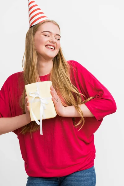 Fröhliche junge Frau in Partymütze mit Geschenk auf weißem Hintergrund — Stockfoto