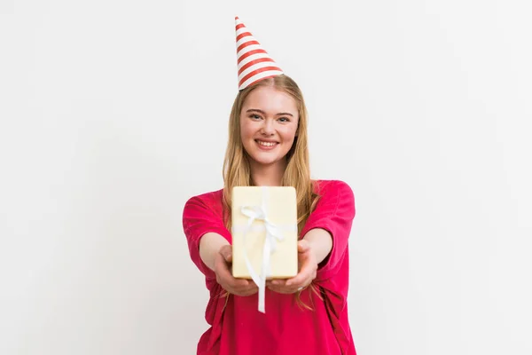 Foco seletivo da menina alegre em festa cap segurando presente isolado no branco — Fotografia de Stock