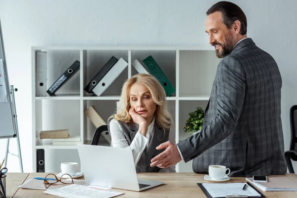 Hombre Negocios Sonriente Apuntando Con Mano Computadora Portátil Cerca Mujer — Foto de Stock