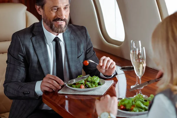 Selective Focus Smiling Businessman Eating Salad Businesswoman Champagne Plane — Stock Photo, Image