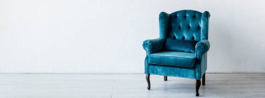 panoramic crop of blue and comfortable armchair near white wall in living room  clipart