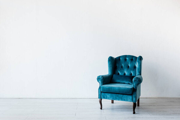 blue and comfortable armchair near white wall in living room 