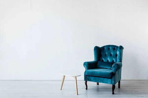 Oturma odasındaki sehpanın yanında rahat bir koltuk. 