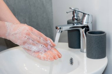 cropped view of young woman washing soapy hands in bathroom  clipart