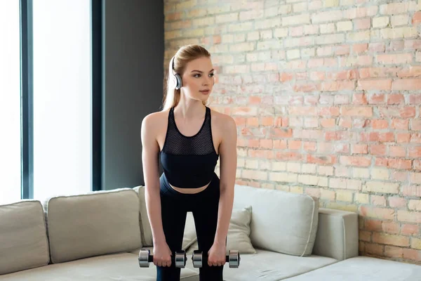 Chica Deportiva Auriculares Inalámbricos Haciendo Ejercicio Con Mancuernas Casa —  Fotos de Stock