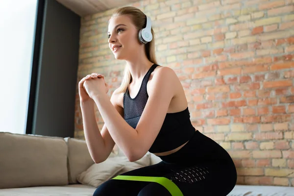 Kablosuz Kulaklıklı Mutlu Sporcu Kadın Evde Oturarak Egzersiz Yapıyor — Stok fotoğraf